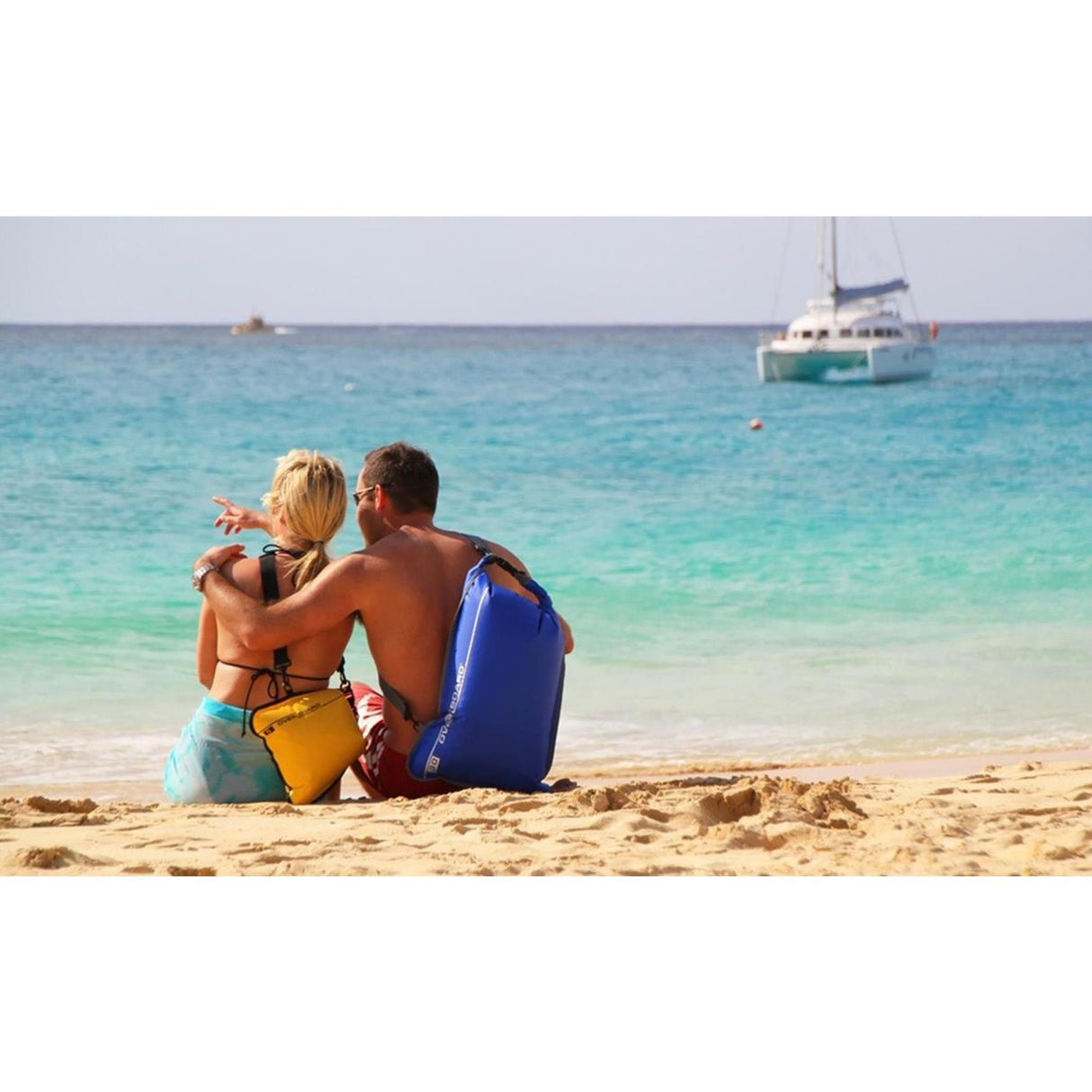 OverBoard wasserdichte Tasche 30L blau, Paar am Strand mit Tasche, Draufsicht