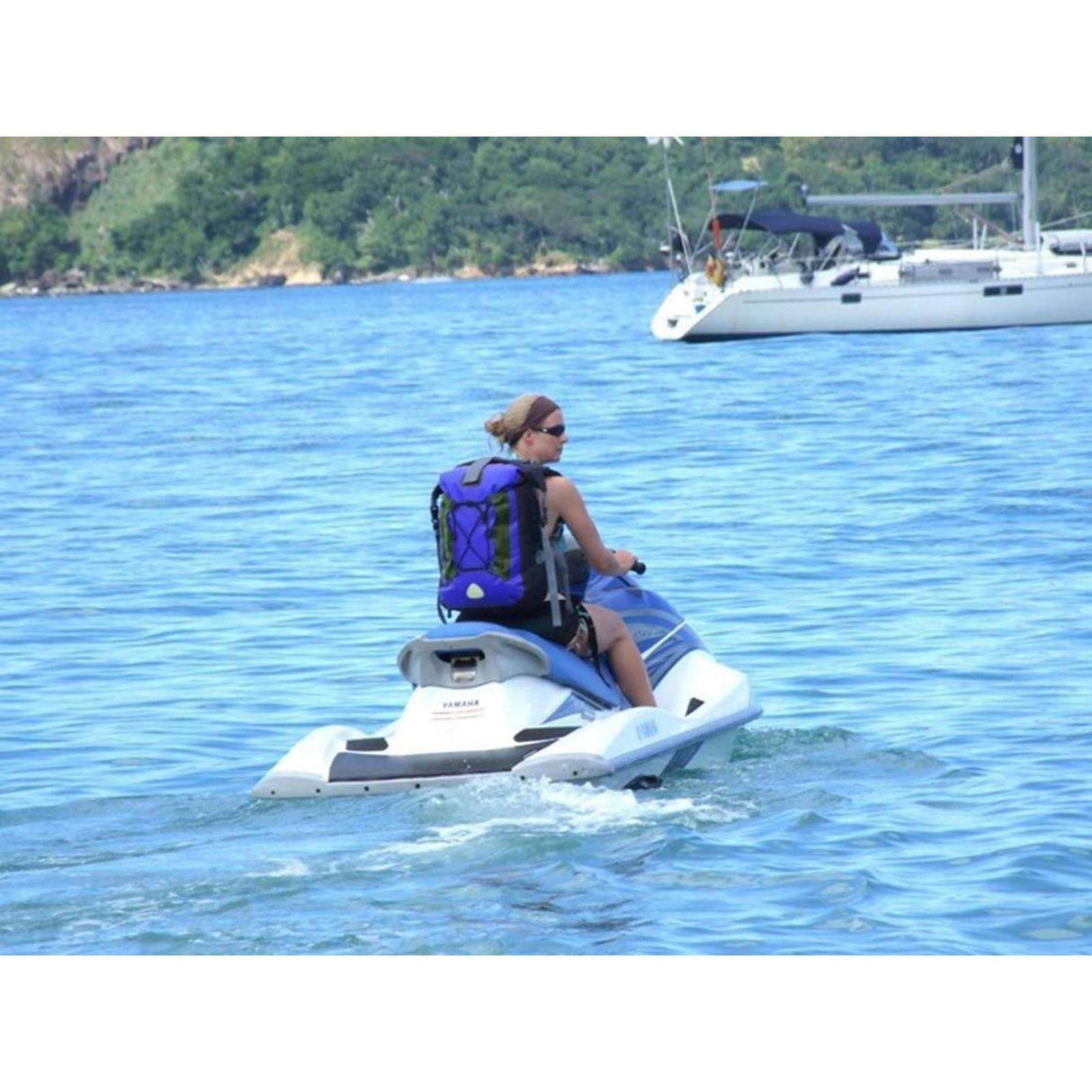 OverBoard Classic Wasserdichter Rucksack in Blau, getragen auf Jet Ski am Wasser, robustes Design