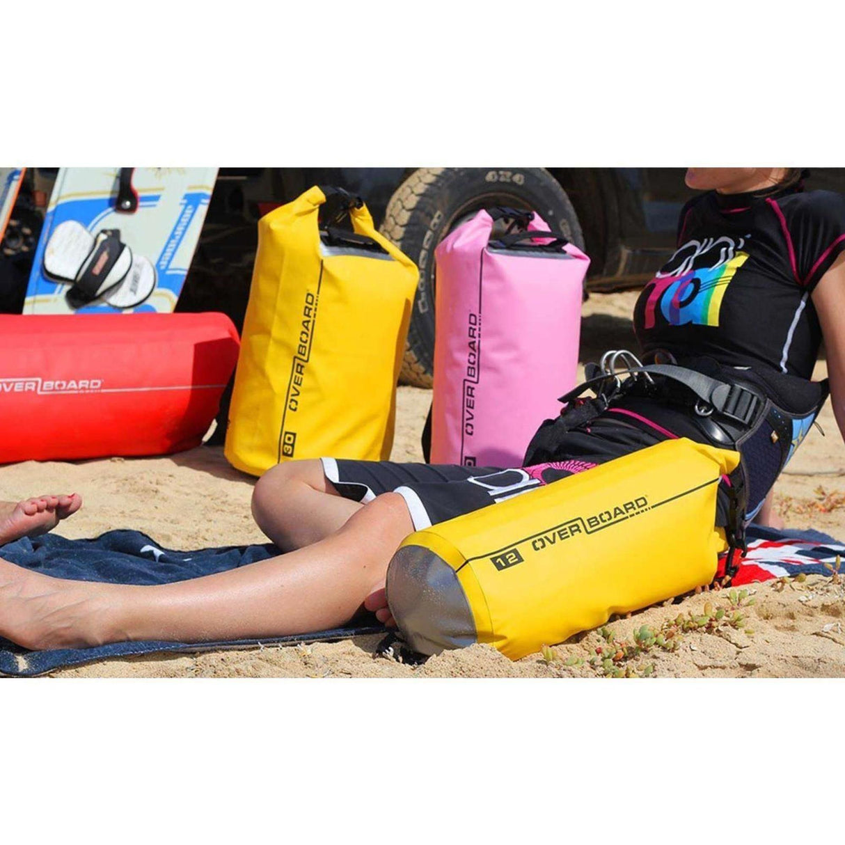 OverBoard wasserdichter Packsack 12 Liter in Gelb, Rosa und Rot, rollbar verschlossene Drybags am Strand