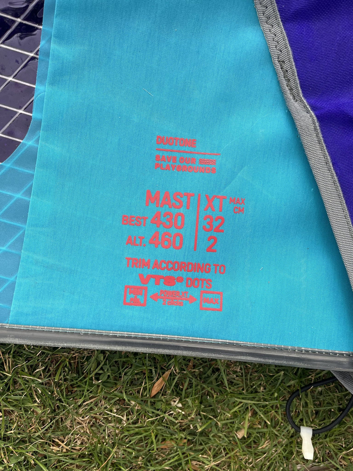 Duotone S-Pace 6.6 2026 Kiteboard Oberseite in Türkis und Blau mit roten Spezifikationen, Draufsicht auf Gras