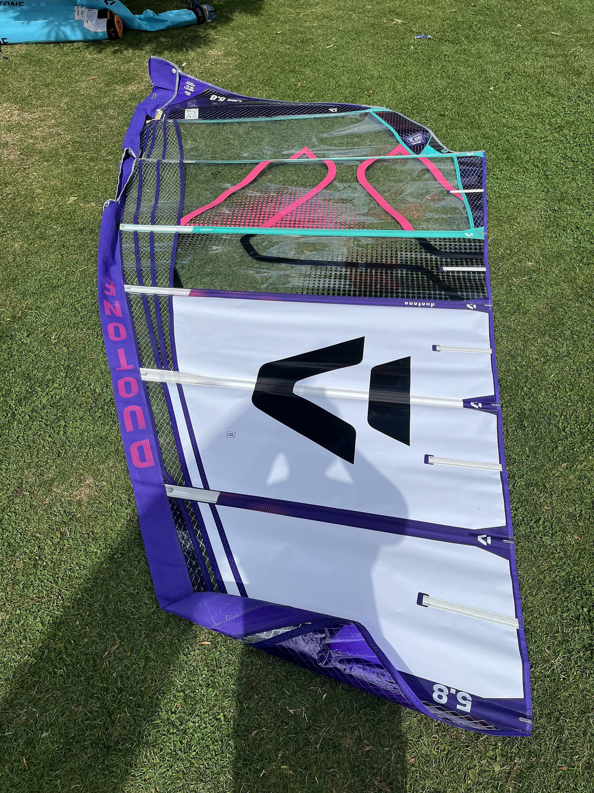 Duotone X Pace 5.8 2026 Kitesegel lila-weiß mit schwarzem Logo, auf Wiese ausgelegt, Seitenansicht