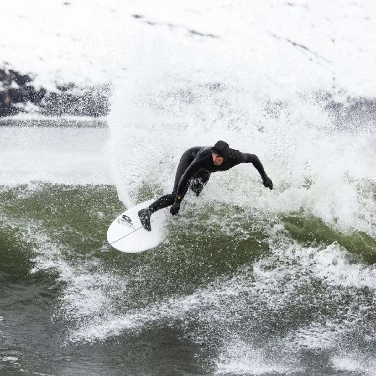 MDNS Neopren Haube Prime in Schwarz, Surfer auf Welle im Wasser tragend