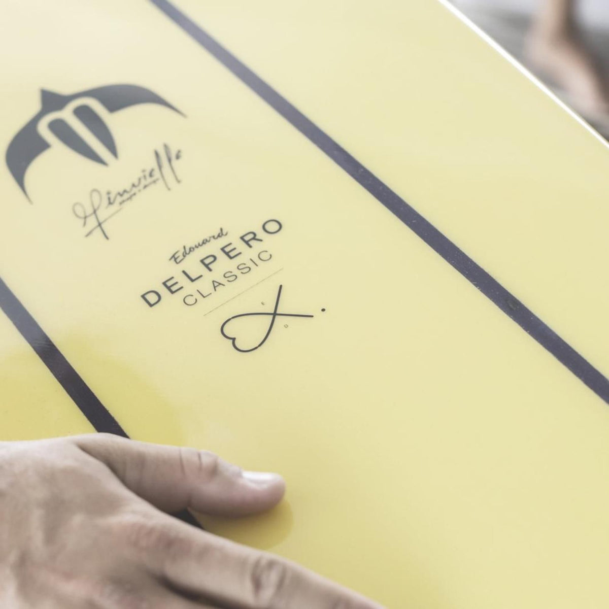 Torq TEC Delpero Classic Surfboard in Gelb mit Delphin-Logo und Signatur, Detailaufnahme des Decks