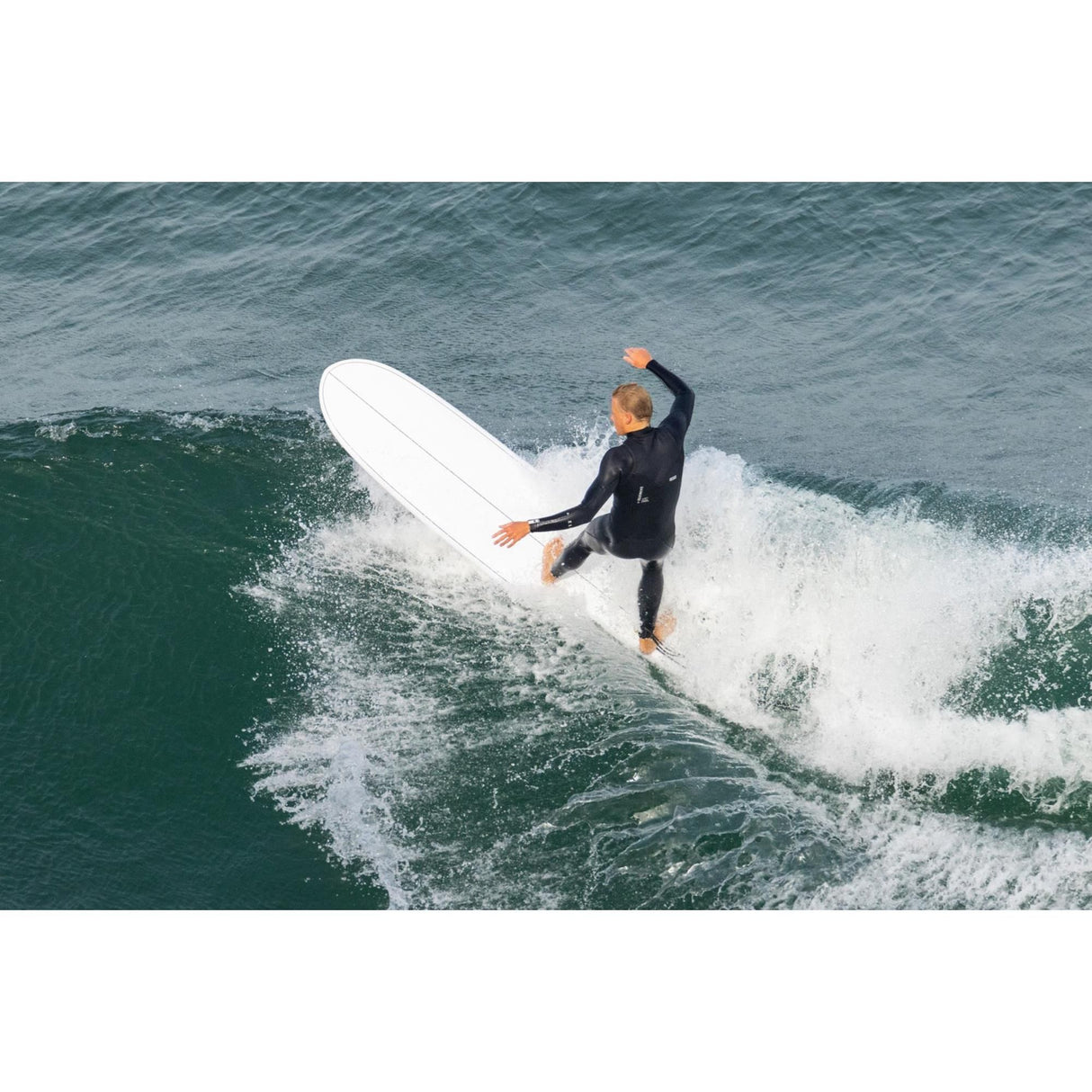 Torq TEC 24/7 Surfboard weiß, in Aktion auf Welle, Surfer in Neoprenanzug von oben