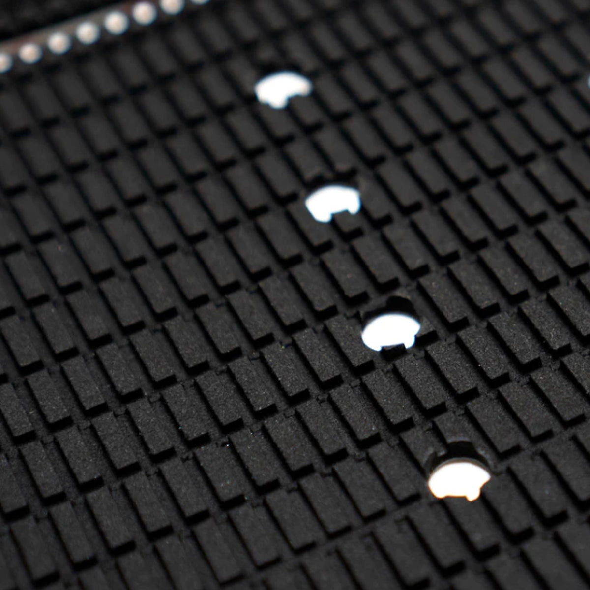 Futures Traction Landing Pad Surfboard Footpad schwarz mit Noppen und weißen Befestigungslöchern, Nahaufnahme