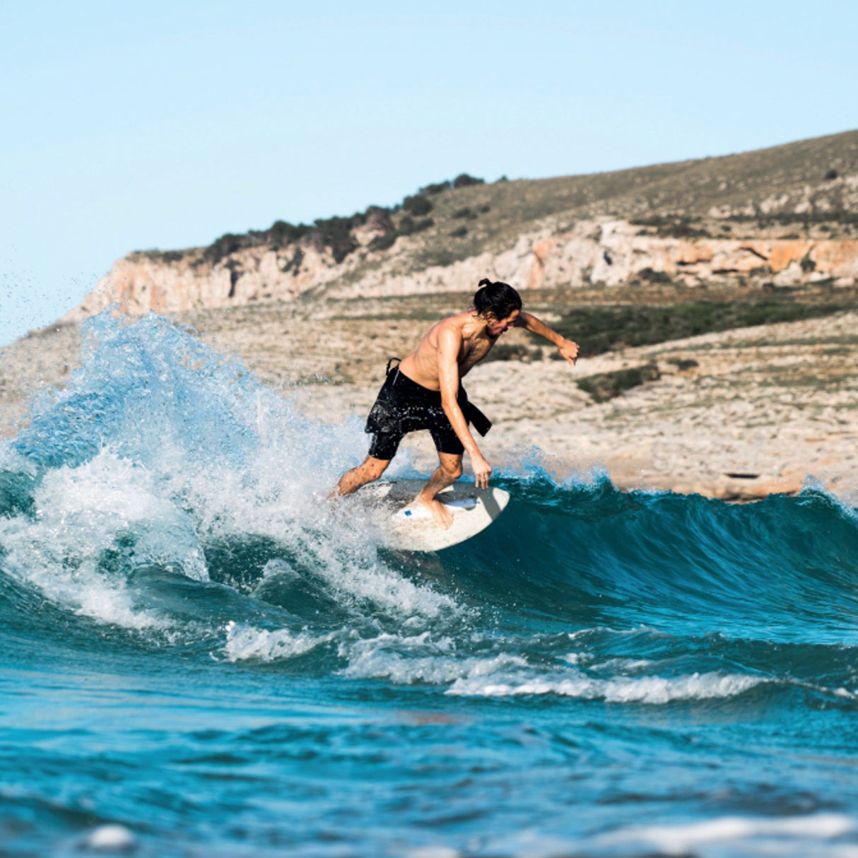 SkimOne EPS Epoxy Bambus Clover Skimboard in Weiß-Grün, Athlet beim Skimmen auf Welle