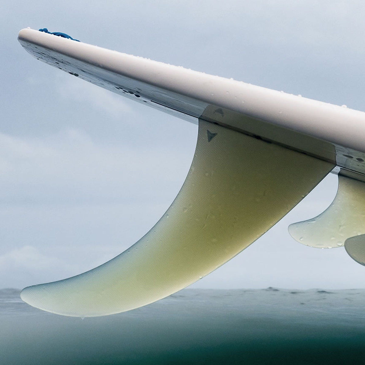 ROAM Surfboard Single Finne Flex US Box, weiß-grüne Finne, Seitenansicht über Wasser