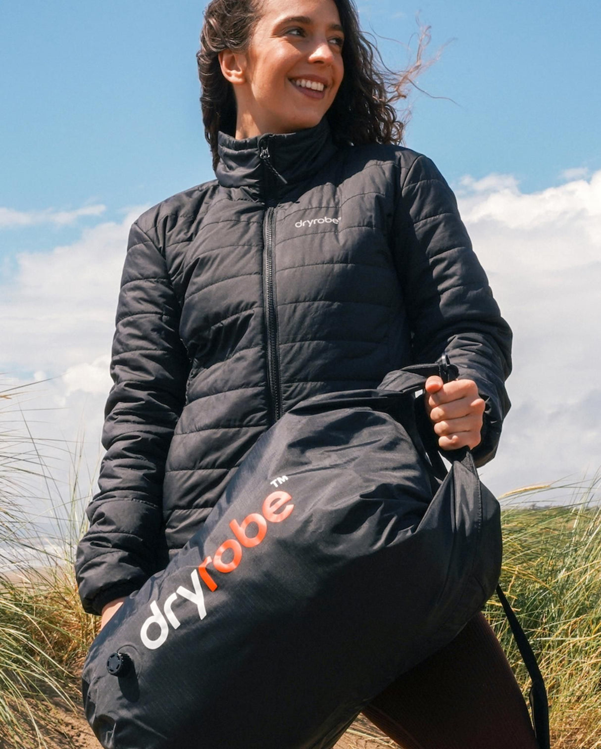Dryrobe wasserdichter Drybag Packsack in Schwarz, von Frau in Natur getragen, robustes Nylon-Material