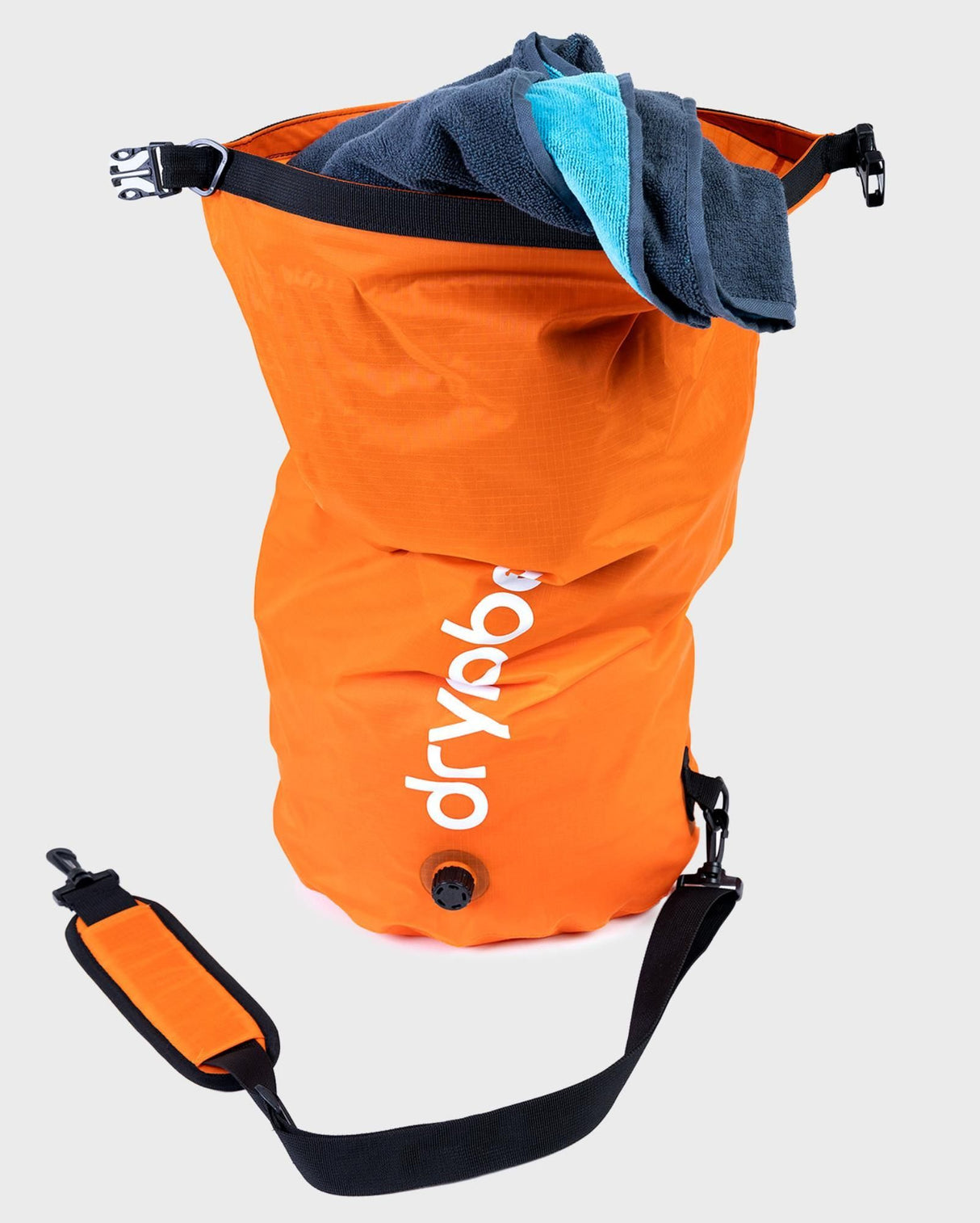 Dryrobe wasserdichter Packsack in Orange mit schwarzen Griffen, gefüllt mit Handtuch, Frontansicht mit Schultergurt
