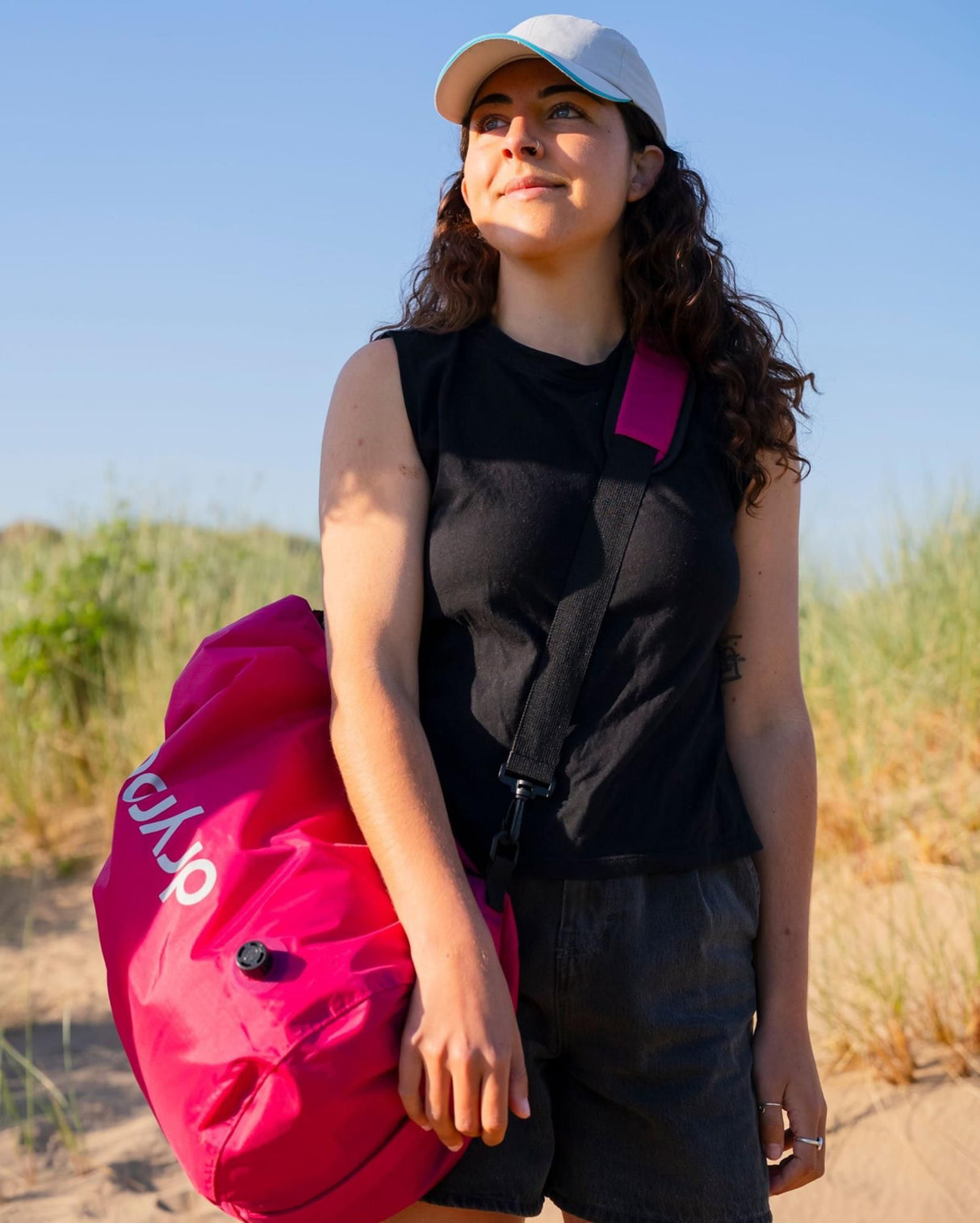 Dryrobe wasserdichter Packsack Drybag in Pink, von Person in freier Natur gehalten, robustes Material sichtbar