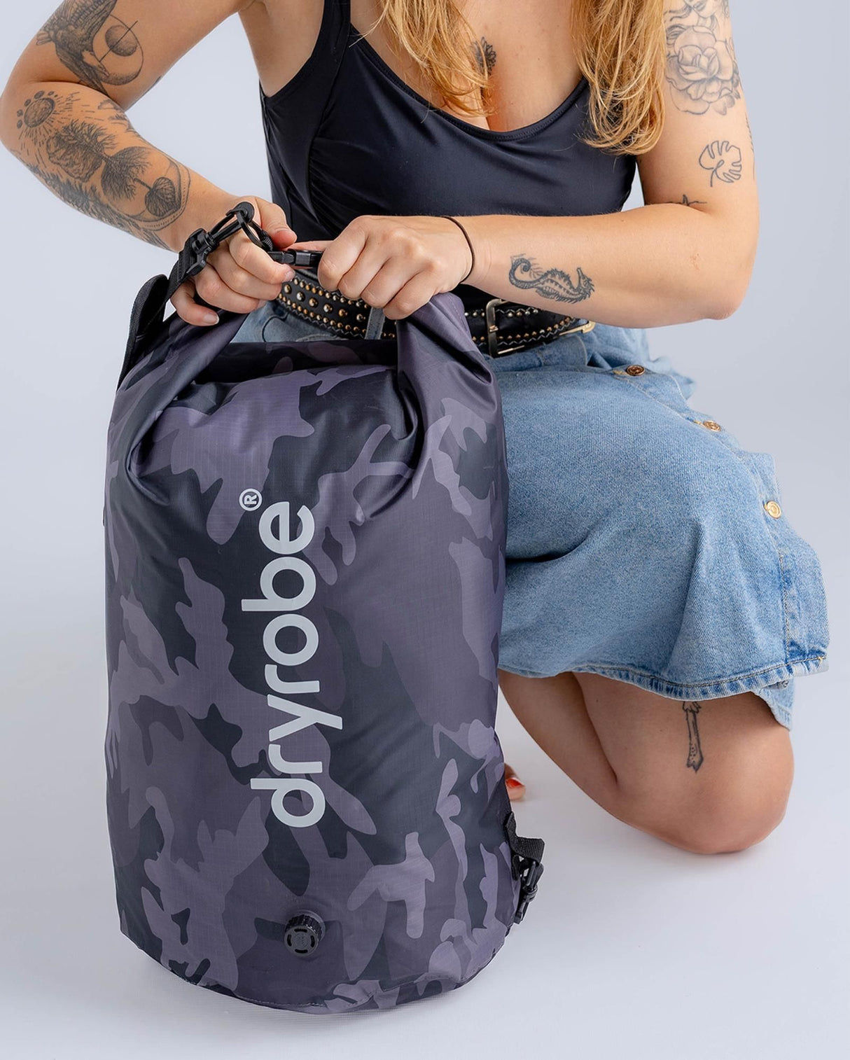 Dryrobe wasserdichter Packsack in Grau mit Camouflage-Muster, geöffnet gehalten von einer Person