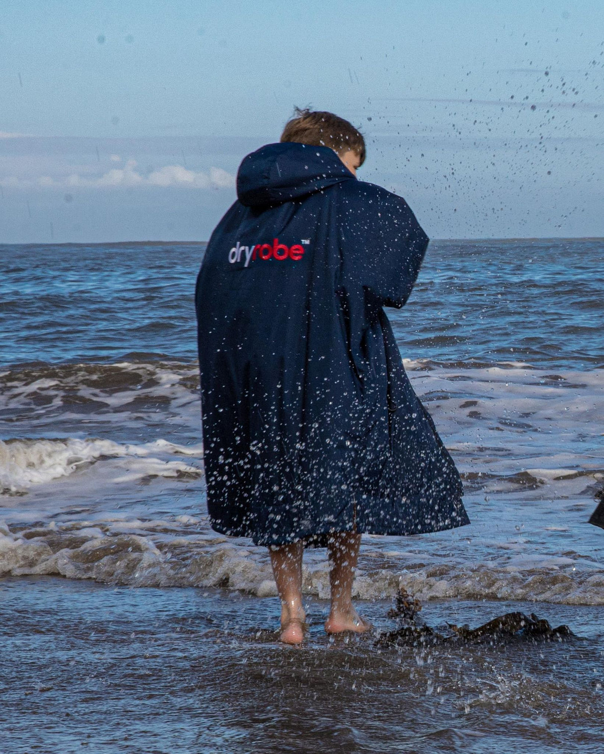 Dryrobe Advance Long Sleeve Kids Bademantel in Marineblau, wasserabweisend, Kind am Strand von hinten