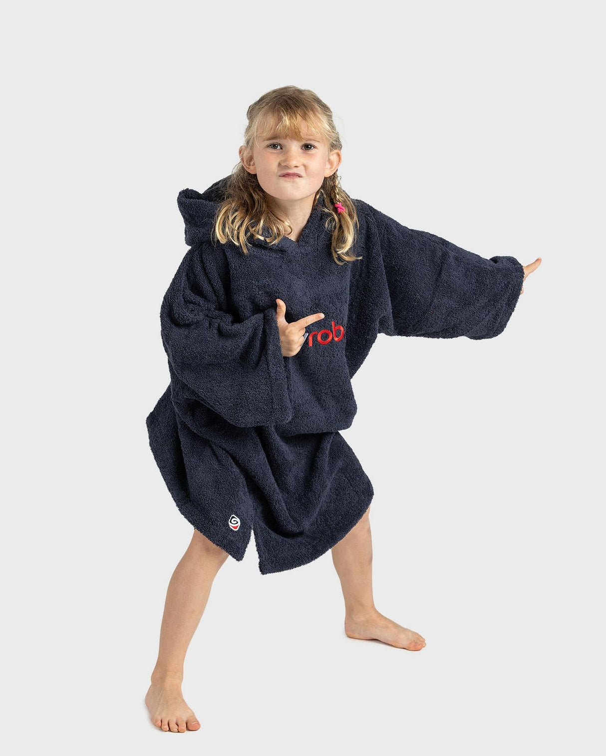 Dryrobe Handtuchmantel Bio Kids in Dunkelblau, Mädchen trägt Bademantel aus Bio-Baumwolle mit Kapuze und roten Logo-Details