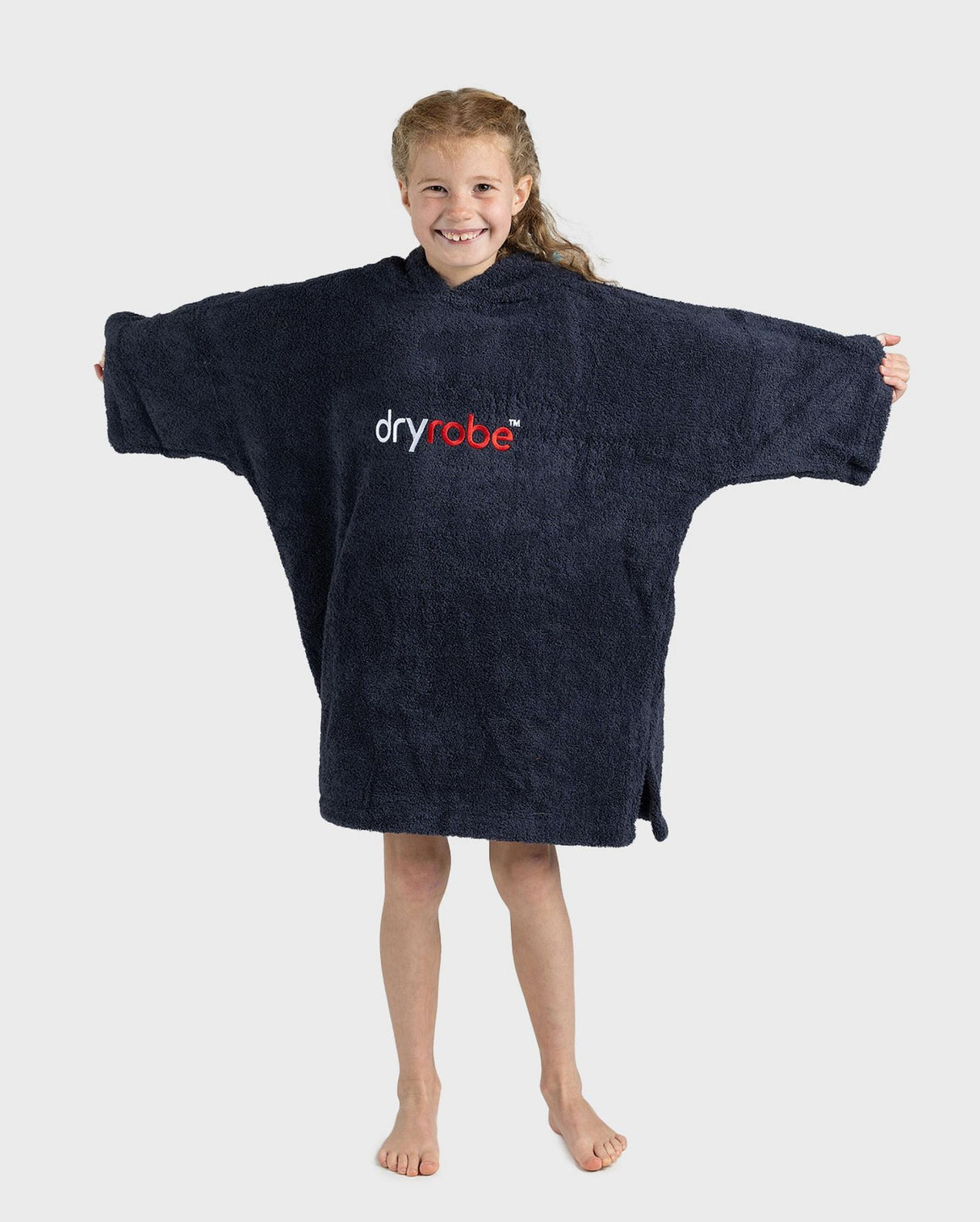 Dryrobe Handtuchmantel Bio Kids in Dunkelblau, Frontalansicht, Kind trägt übergroßen Bademantel mit Logo