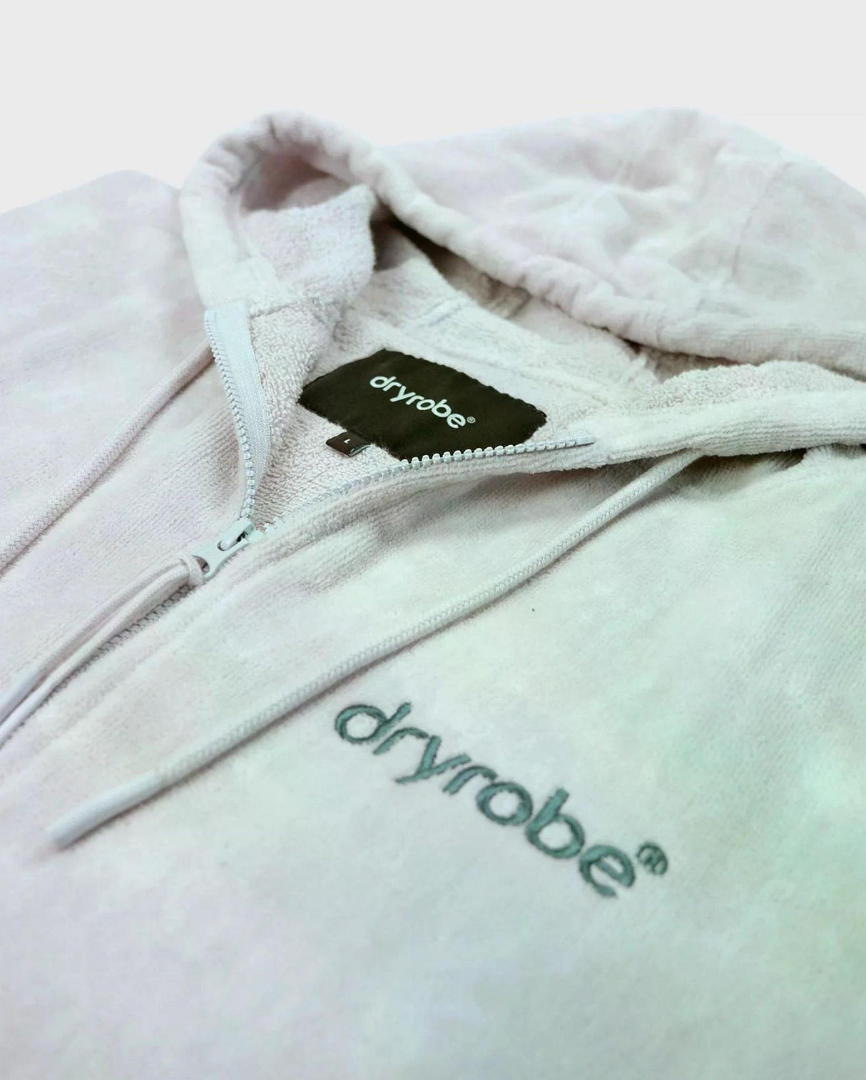 Dryrobe Fullzip Handtuchmantel aus Bio-Baumwolle in Weiß, Detailansicht von Reißverschluss und Logo