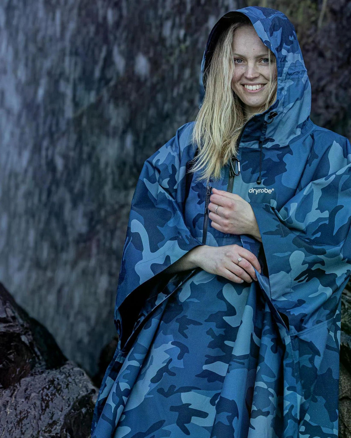 Dryrobe Regen-Poncho in Blau-Camouflage, wasserdicht, mit Kapuze, Frau trägt Poncho im Regen