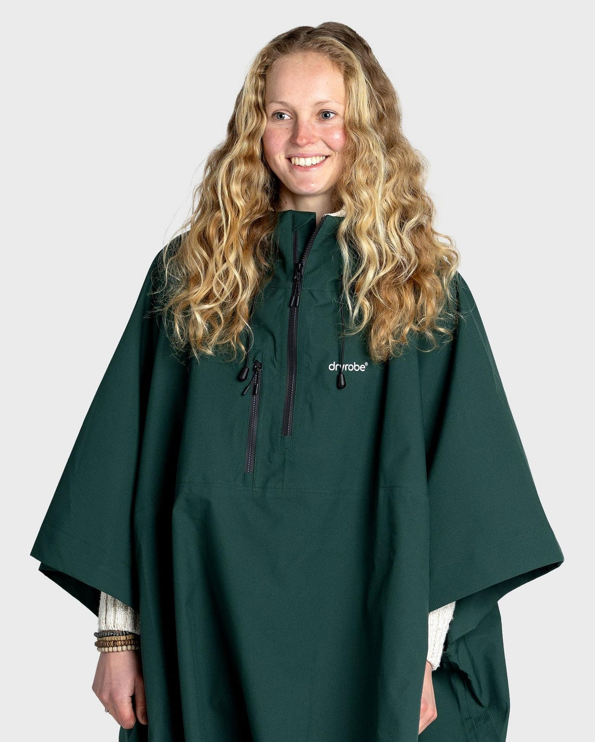 Dryrobe Regen-Poncho wasserdicht in Dunkelgrün, getragen von einer Frau, Frontalansicht mit Kapuze und Reißverschluss