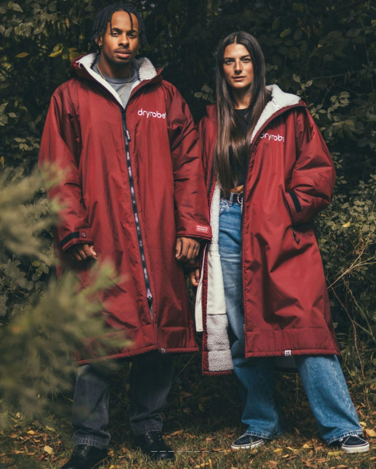 Dryrobe Advance Long Sleeve in Burgundy mit Sherpa-Futter, getragen von zwei Personen in Außenumgebung