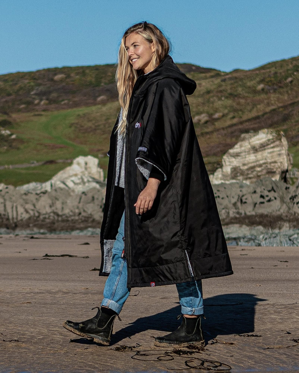 DRYROBE Advance Short Sleeve schwarze Wechselrobe mit Kapuze, getragen am Strand, Frontalansicht
