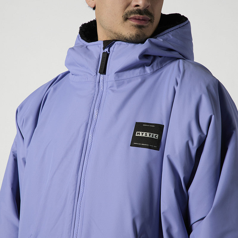 Mystic Poncho Explore Jacke in Dunkelgrün mit schwarzer Kapuze, Frontalansicht auf Model getragen