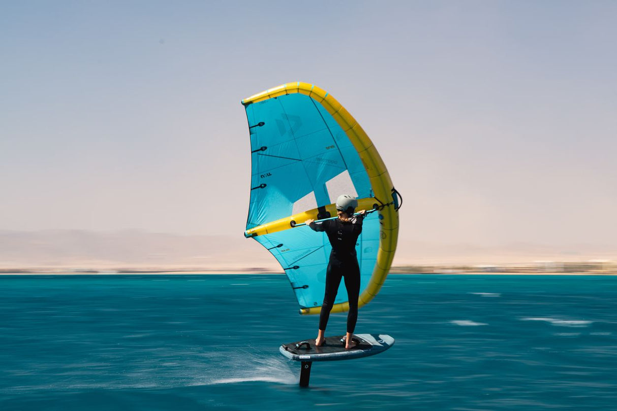 Duotone Unit D/LAB 2027 Windsurfegel blau-gelb, Sportler auf Board im Wasser von vorne