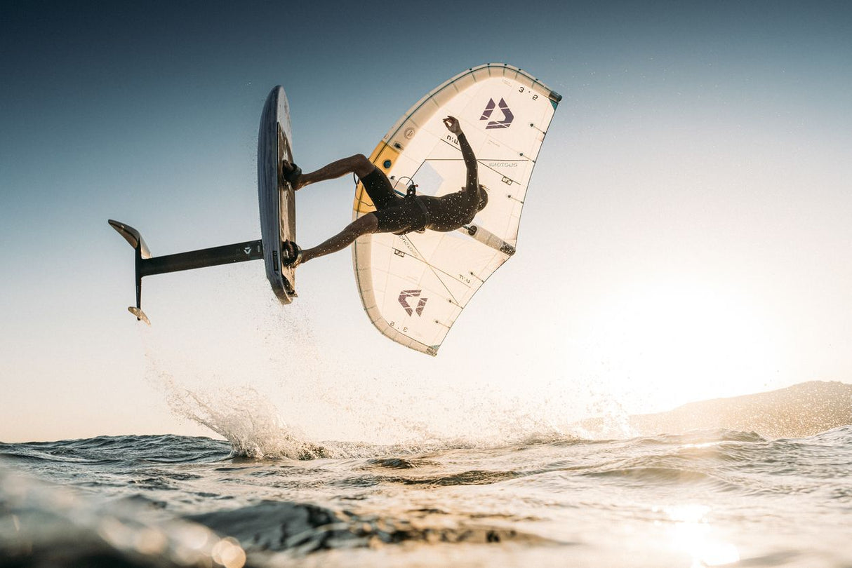Duotone Unit SLS 2027 Kiteboard mit schwarzen Streben in Aktion über einer Welle, Draufsicht