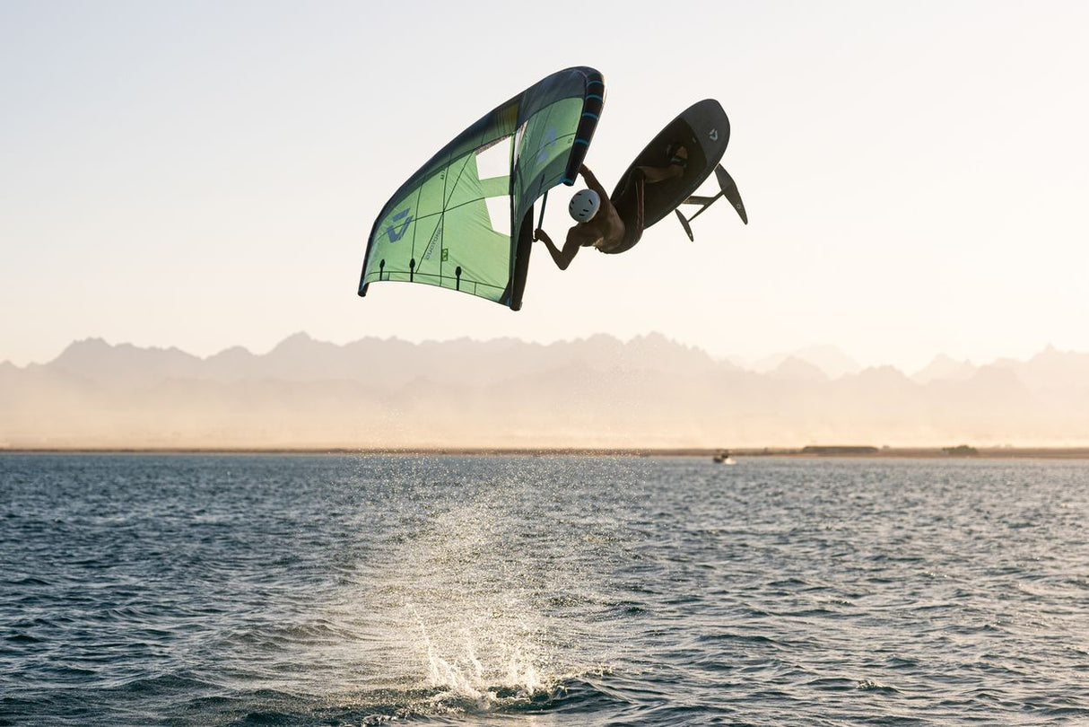 Duotone Unit SLS 2027 Kitesegel in Grün-Schwarz, in Aktion über dem Wasser mit Kiter in Sprungposition