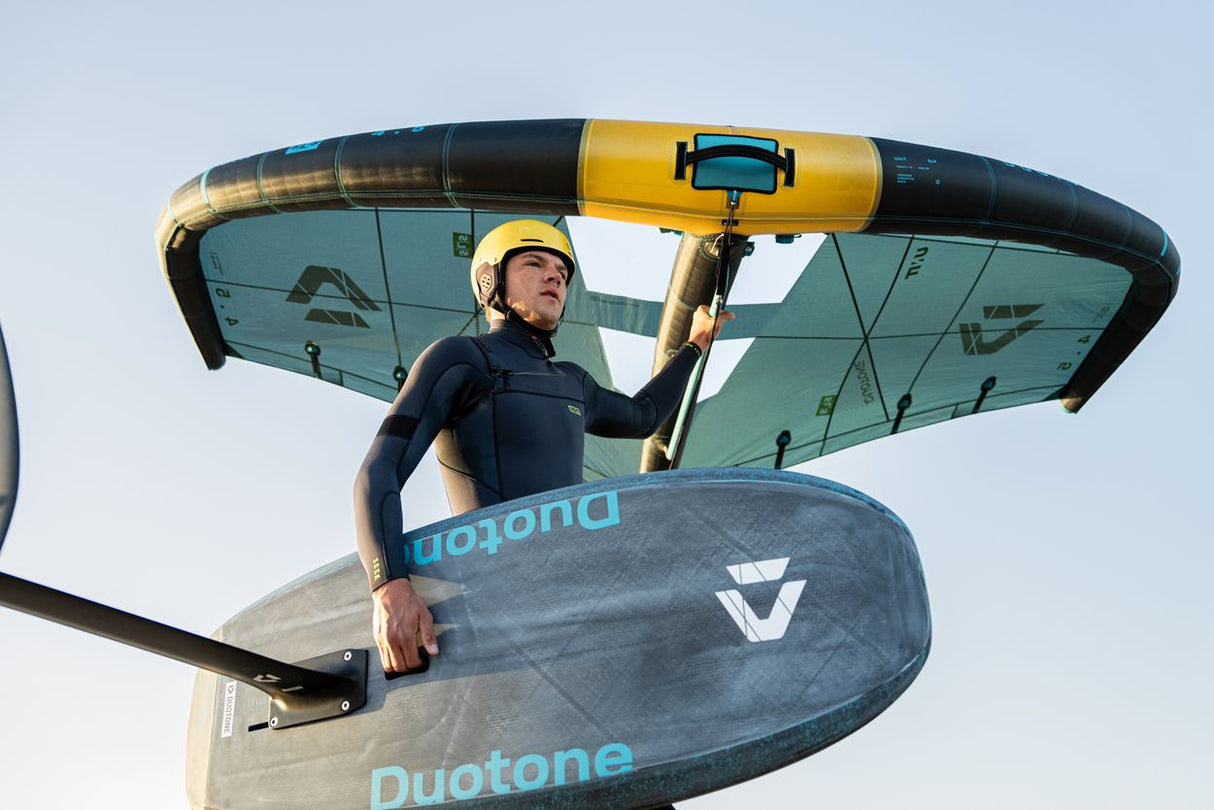 Duotone Sky Style SLS 2027 Kite in Gelb und Schwarz, Sportler trägt Helm und hält Kite, Frontalansicht