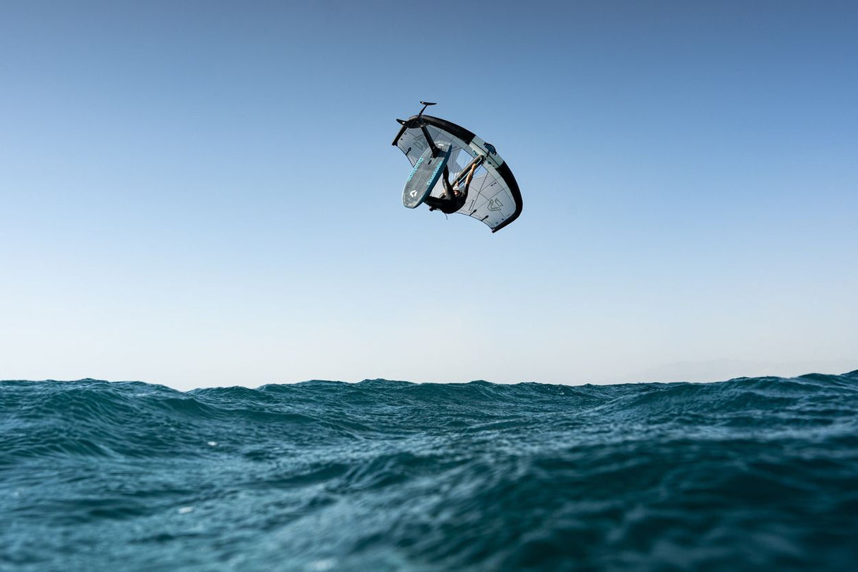 Duotone Sky Style SLS 2027 Kiteboard in Aktion über Wellen, Luftaufnahme mit klarem Himmel