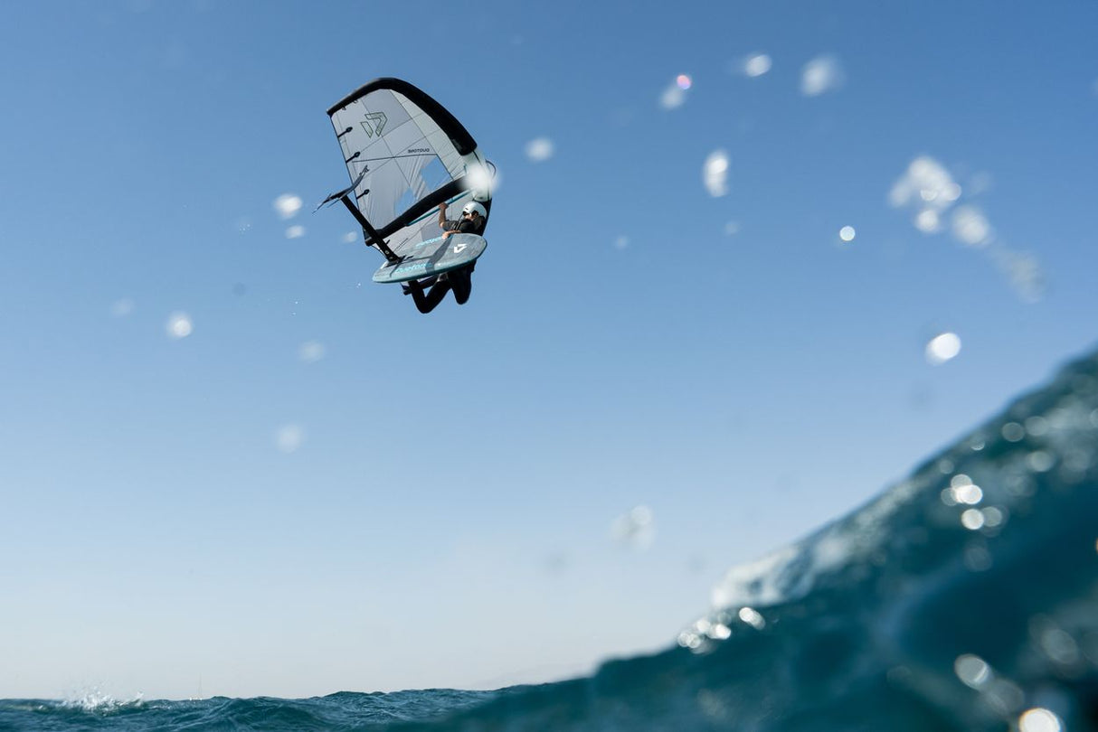 Duotone Sky Style SLS 2027 Kiteboard in Aktion über Wasser vor blauem Himmel, Untersicht