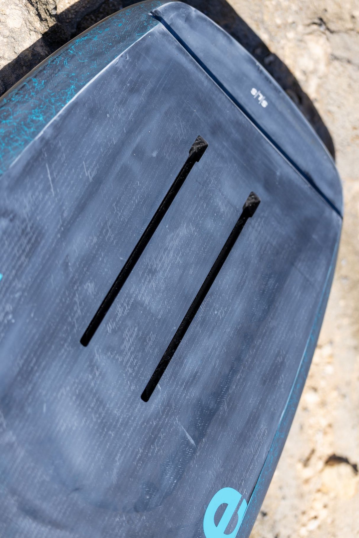 Duotone Sky Style SLS 2027 Kiteboard mit blauem Deck, schwarzen Streben und türkiser Beschriftung, Draufsicht