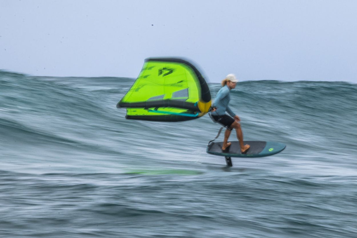 Duotone Skybrid SLS 2027 Kitesegel in Neongelb und Dunkelblau, Kitesurfer in Aktion auf dem Wasser