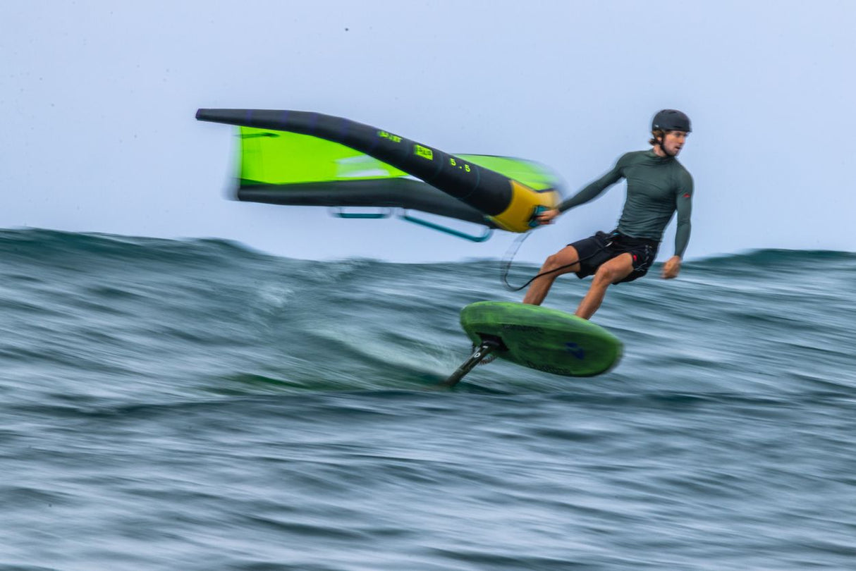Duotone Trace SLS 2027 Kite in Neongrün und Schwarz, Kitesurfer in Aktion auf dem Wasser in dynamischer Fahrt