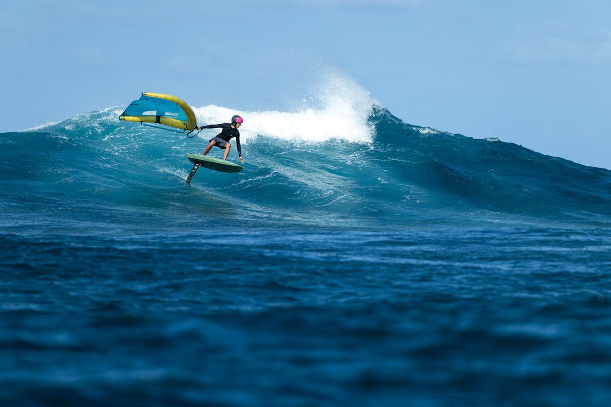 Duotone Trace SLS 2027 Kiteboard in Gelb-Blau, Surfer auf Welle im Meer