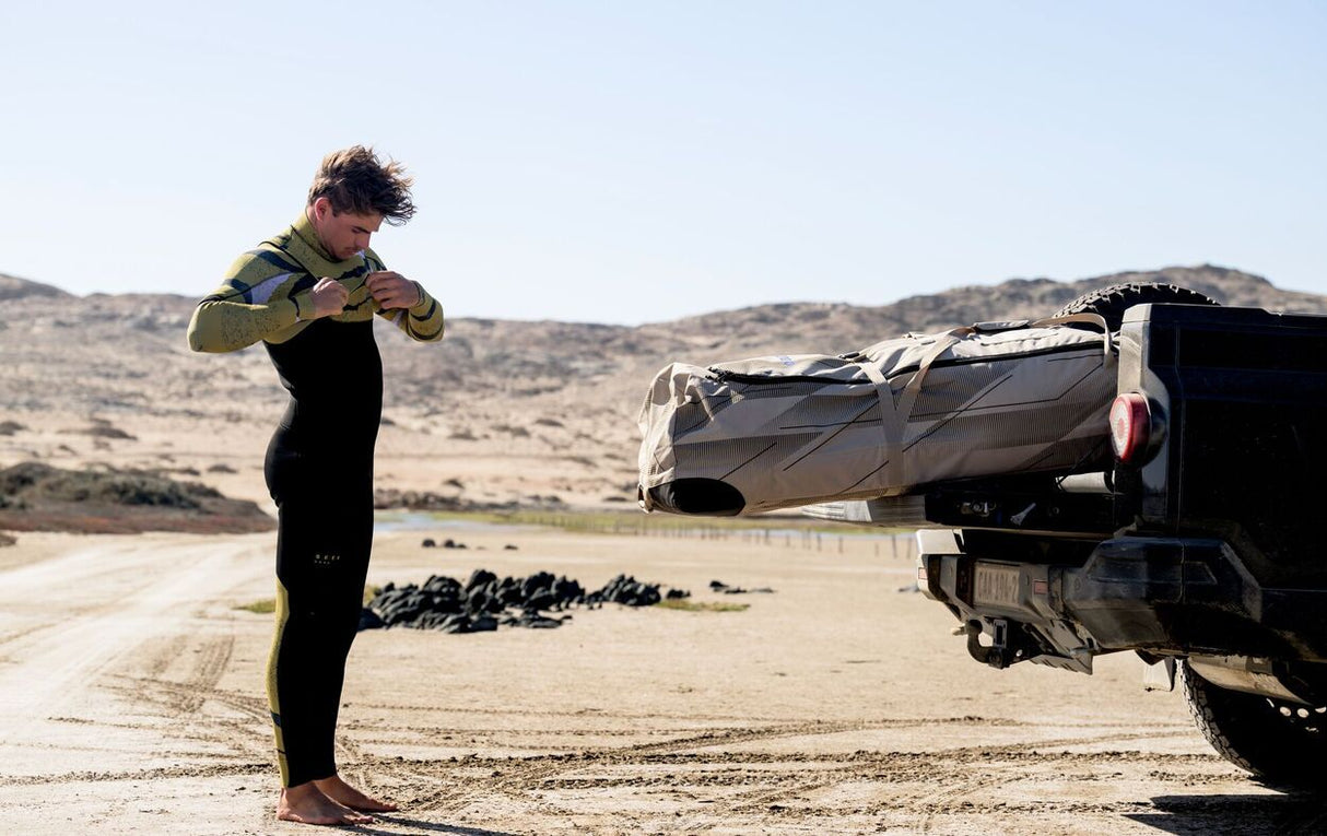 Duotone Combibag 2027 in Schwarz und Grün, Sporttasche mit Trageschlaufen, Frontalansicht bei Outdoor-Nutzung am Strand