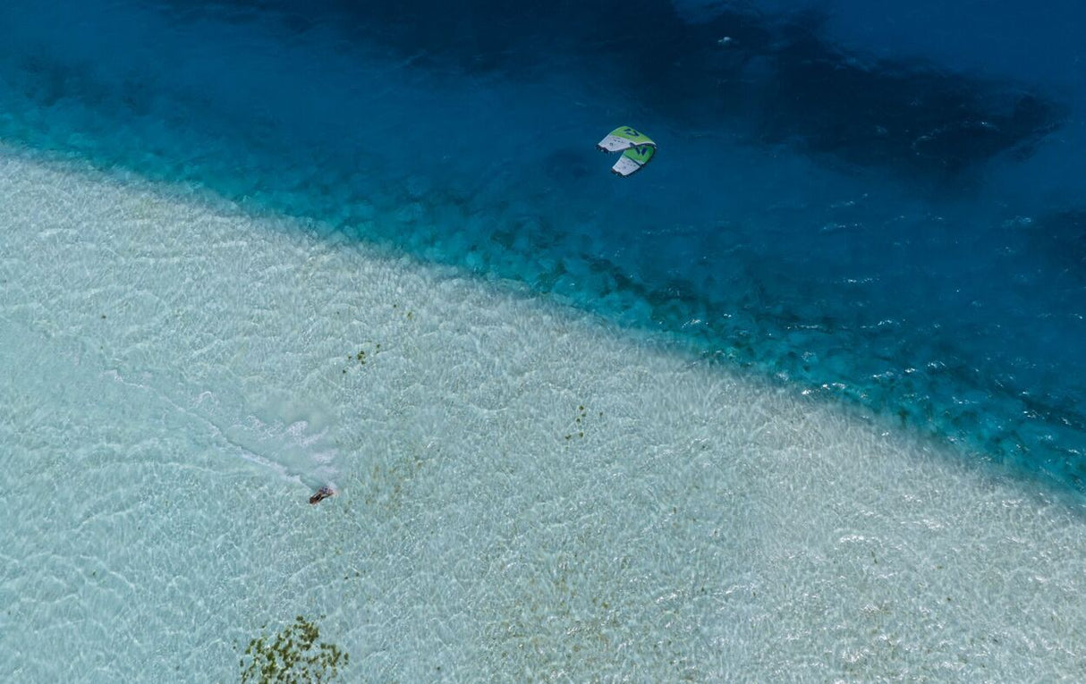 Duotone Neo SLS 2027 Kiteboard Luftaufnahme über türkisblauem Wasser und Sandstrand