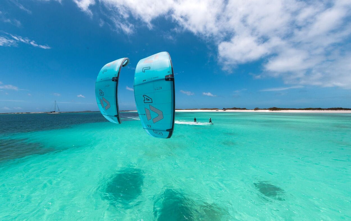 Duotone Evo D/LAB 2027 Kite in Türkis, im flachen Wasser aufgereiht, Frontalansicht mit tropischem Meer und blauem Himmel