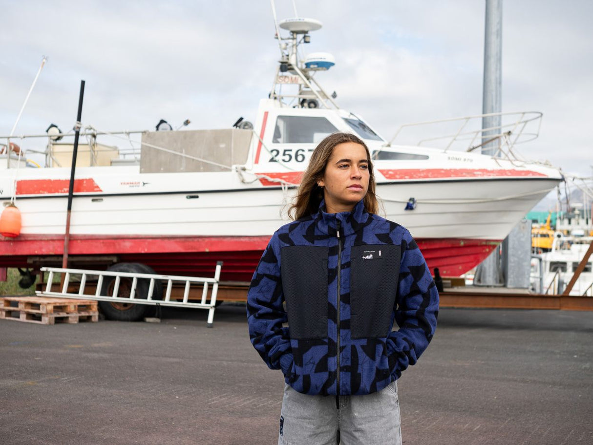 ION HD Fleece Jacke 2026 in Blau und Schwarz, Frontansicht an Modell vor Hafen