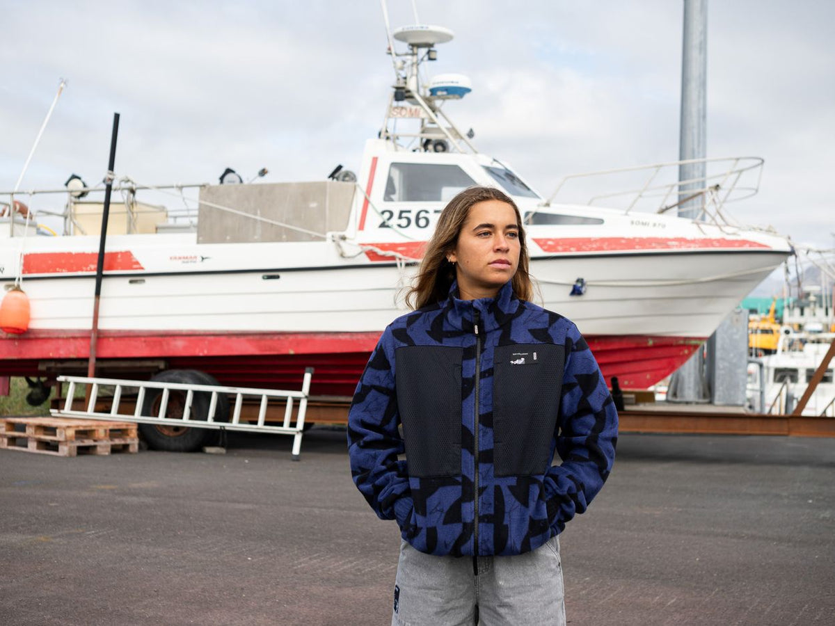 ION HD Fleece Jacke 2026 in Blau und Schwarz, Frontansicht an Modell vor Hafen