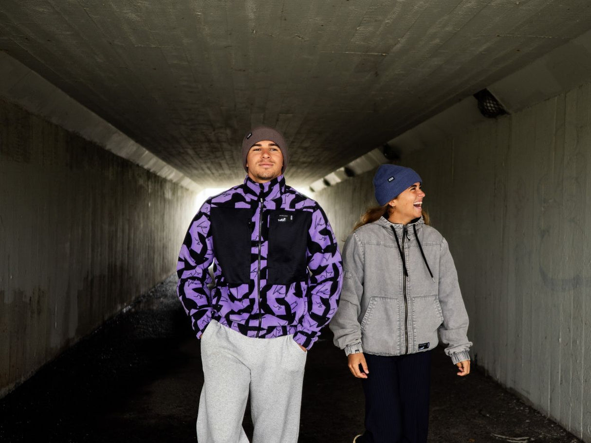 ION HD Insulated Cotton 2026 Jacke in Schwarz und Violett, Frontansicht auf Person in unterirdischem Tunnel getragen