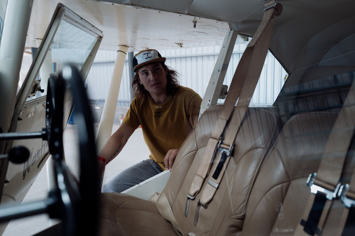 ION Mood 2026 Kiteboard in Verwendung, Fahrer in gelbem Shirt sitzt im Boot, Frontalansicht