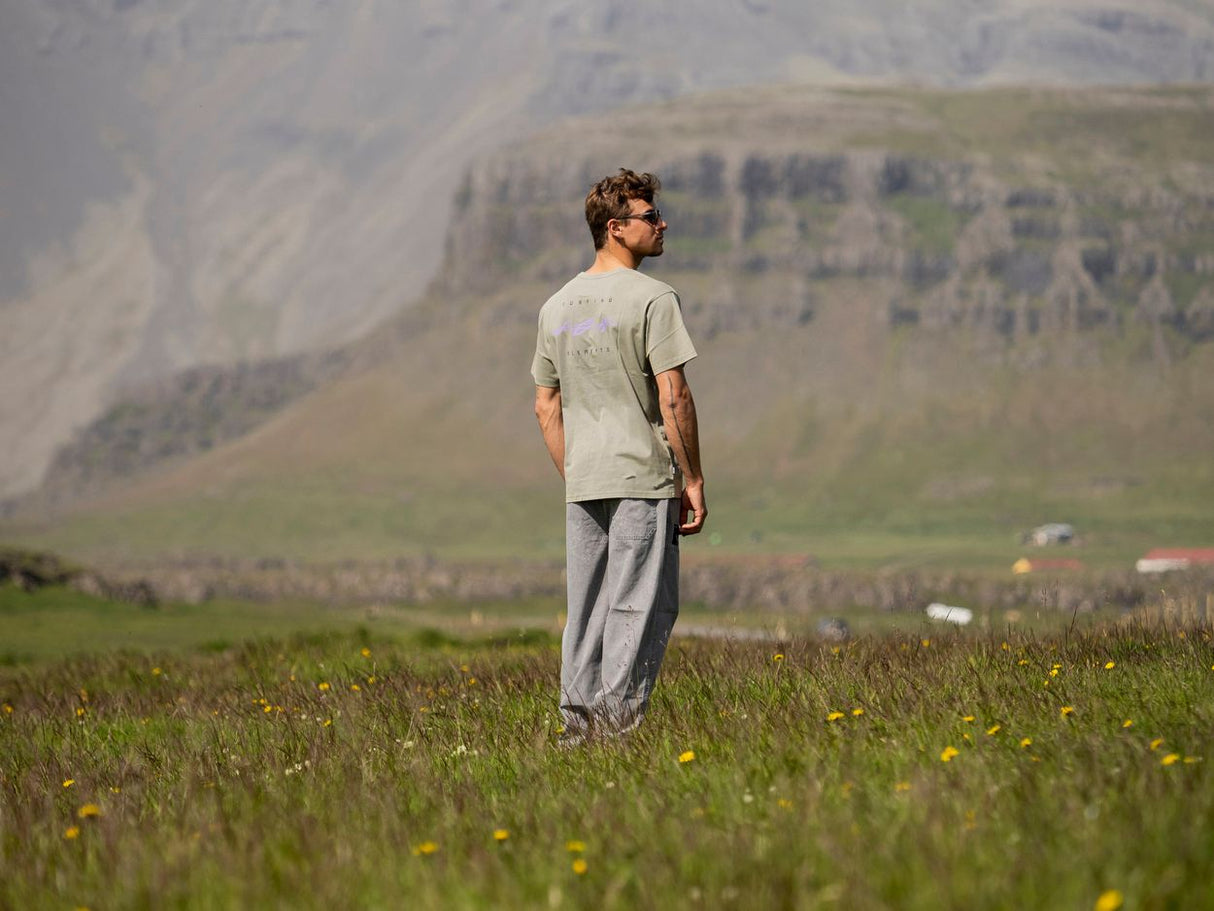 ION Mood 2026 grauer T-Shirt und Hose, Rückenansicht, Person in Berglandschaft mit Wiese