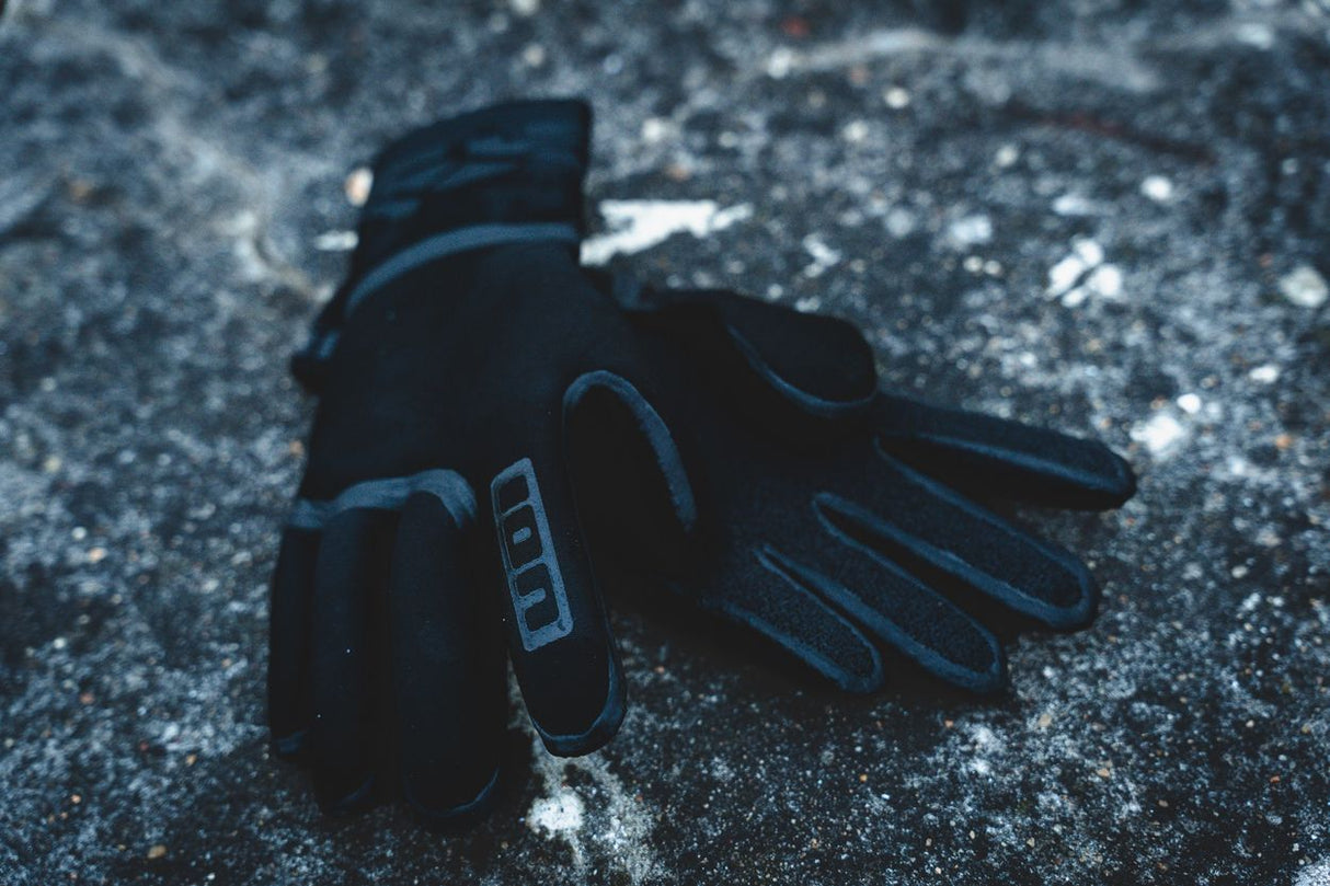 ION Neo Gloves 4/2 2026 schwarz-blau, Neopren-Handschuhe für Wassersport, Detailansicht auf eisiger Oberfläche