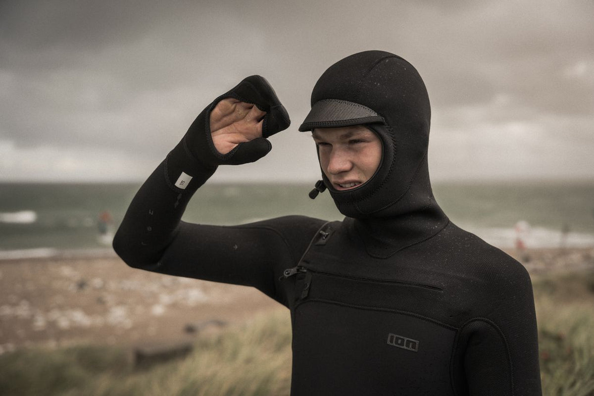 ION Open Palm Mitten 2.5 2026 schwarze Neopren-Handschuhe mit offener Handfläche, Nahaufnahme an Person am Strand