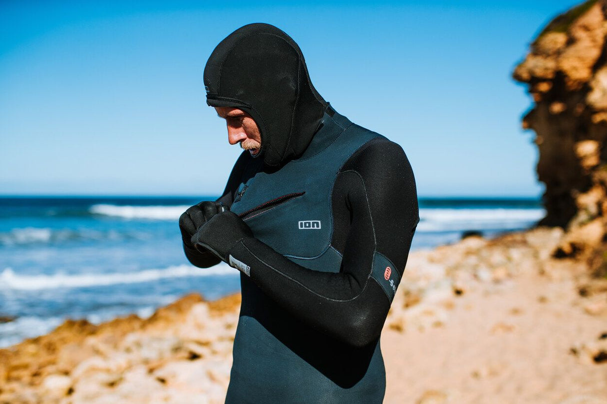 ION Neo Hood 2/1 2026 Neoprenanzug mit Kapuze in Schwarz-Blau, Frontansicht am Strand