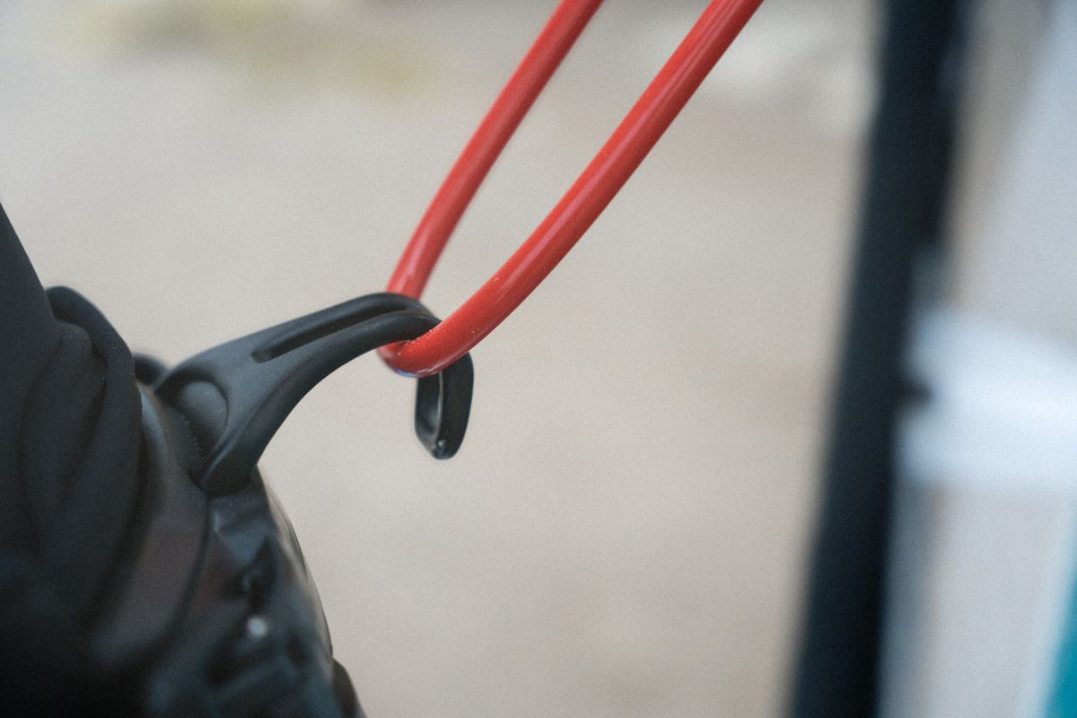 ION Windsurf Harness Line Vario 2026 mit roten Leinen und schwarzem Befestigungssystem, Nahaufnahme der Verbindung