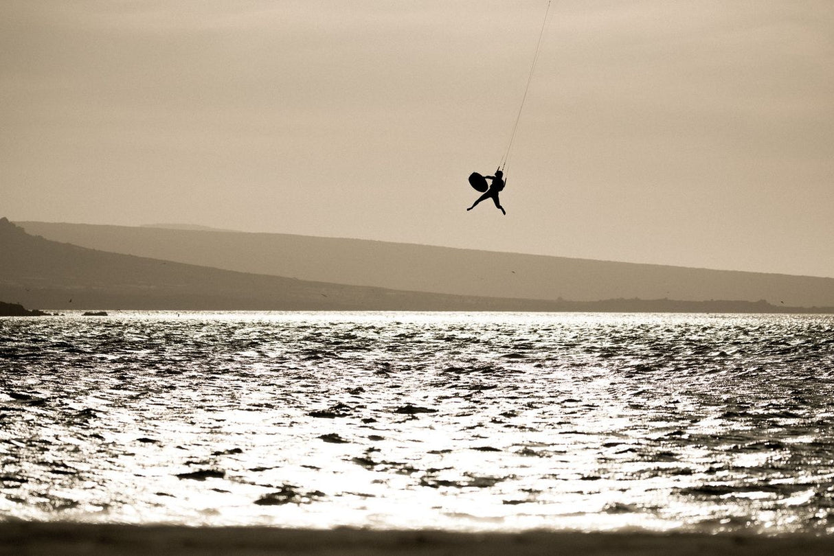 ION Amp Long 2026 Kiteboard in Aktion über Wasser, Seitenansicht beim Kitesurfen