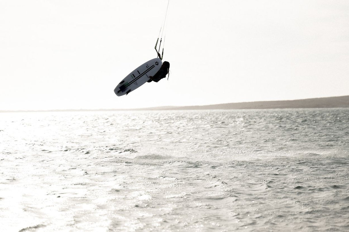 ION Amp Long 2026 Kite in Schwarz, in der Luft über Wasser, Actionaufnahme beim Kitesurfen