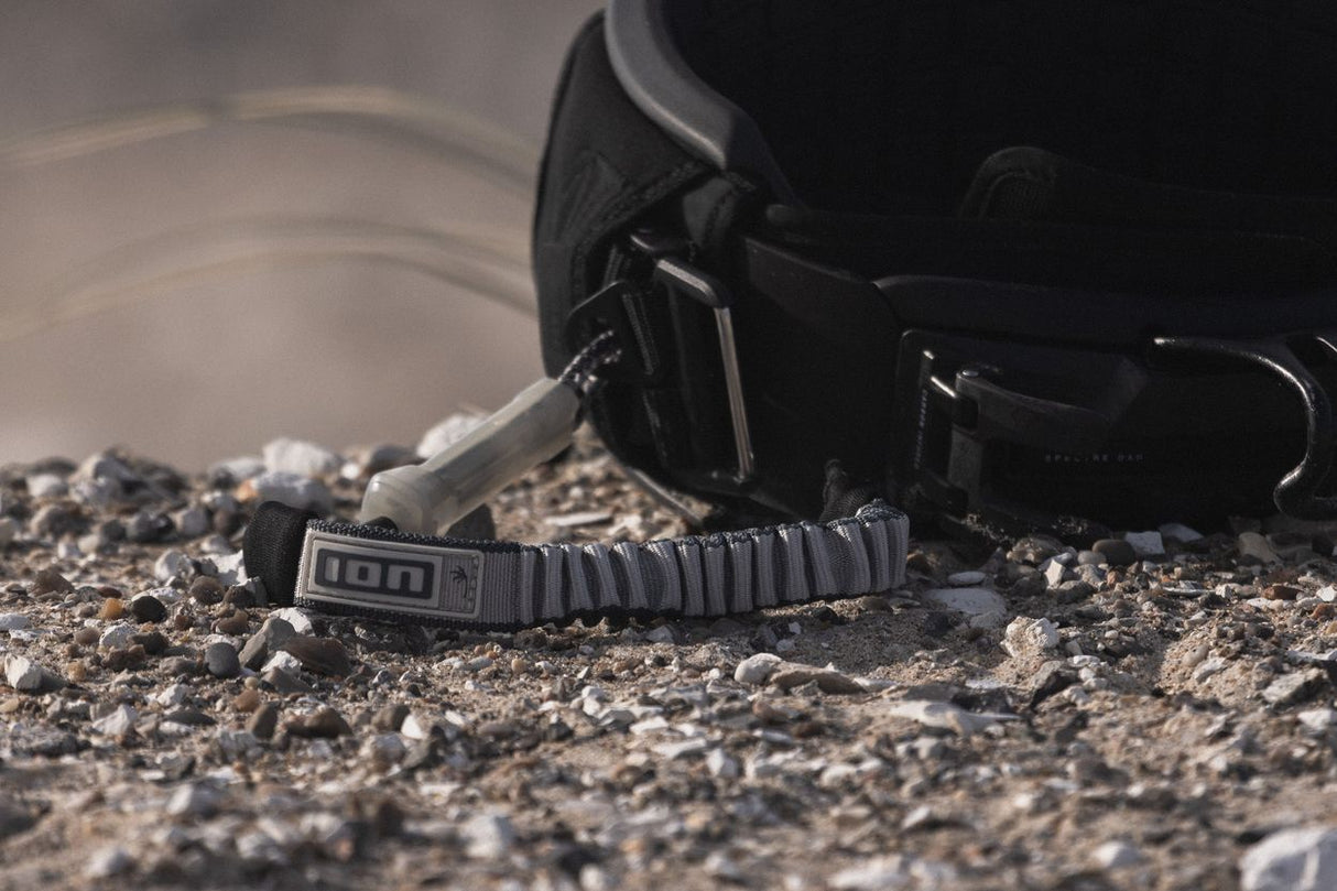 ION Base 2/2 Shorty 2025 Neopren-Shorty in Schwarz mit Klettverschluss, am Strand liegend