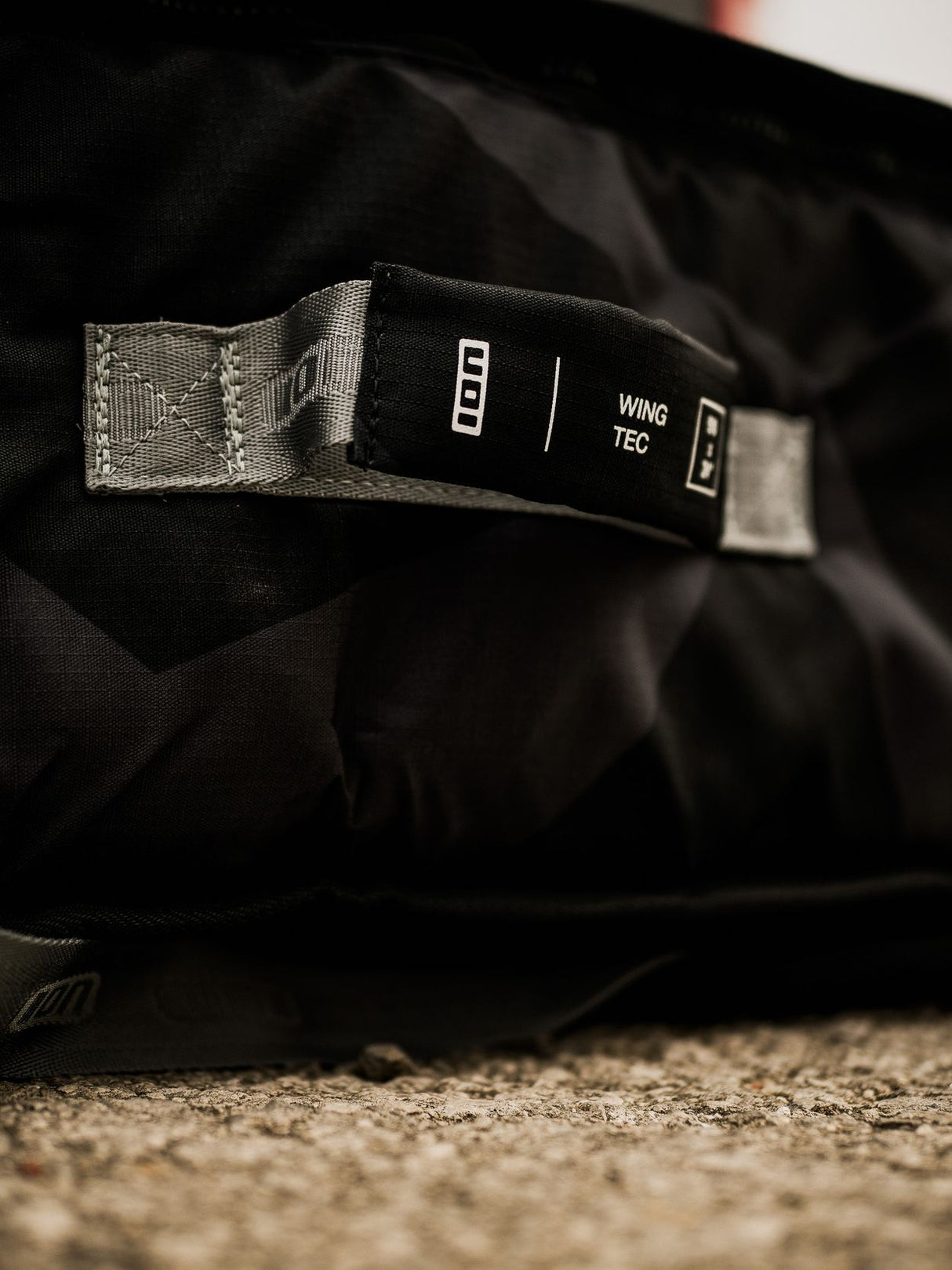 ION Wing Boardbag Tec 2026 schwarz mit Tragegriff und Textilriemen, Detailansicht des Verschlusses